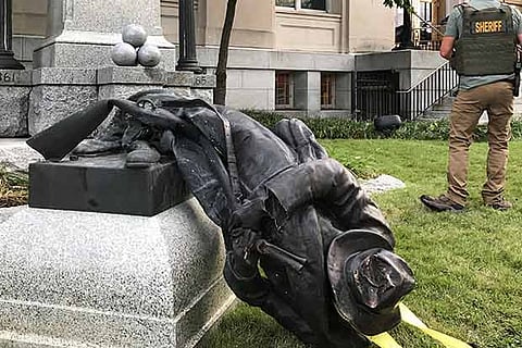 The monument called the ?Confederate Soldiers Monument? lies on the ground after being toppled by protesters