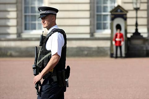 Police officers are seen on duty within the grounds of Buckingham Palace in London