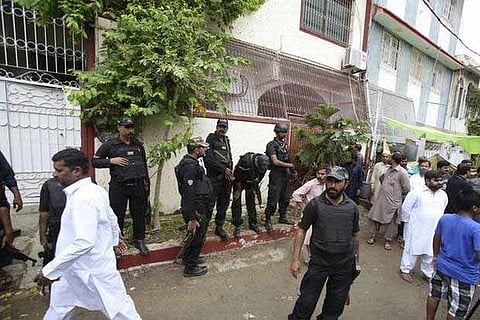Pakistani security personnel stand at the site of an attack on a lawmaker in Karachi