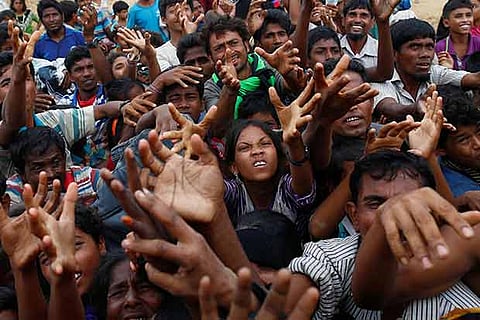 Rohingya refugees receive food distributed by local organizations in Kutupalong, Bangladesh