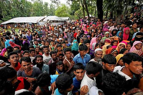 Rohingya refugees gather to collect relief at the Balukhali Makeshift Refugee Camp