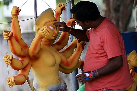Kishori Mohan Pal painting on the features of one of his Durga Pujo idols (Photo: Manivasagan N)
