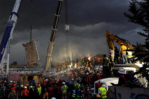 Rescue workers and Mexican soldiers take part in a rescue operation at a collapsed building