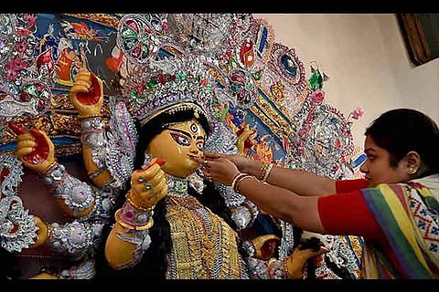An idol of Goddess Durga being being decorated with ornaments during Durga Puja festival, Kolkata