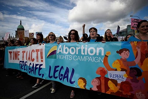Demonstrators hold posters as they march for more liberal Irish abortion laws in Dublin, Ireland