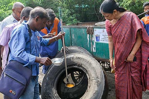 Health Department officials ckeck for breeding dengue  mosquitoes in a drive in the city
