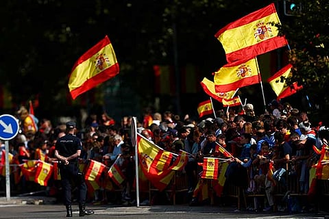 Spectators wave flags during a parade