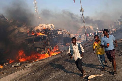 Civilians evacuate from the scene of an explosion in the Hodan district of Mogadishu, Somalia