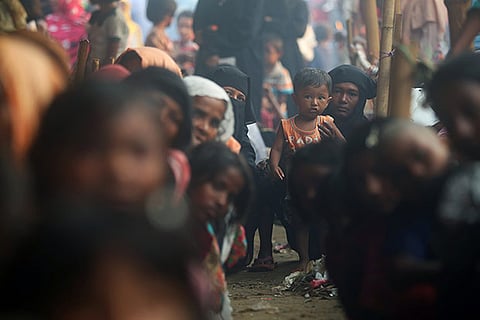 Rohingya refugees line up to receive humanitarian aid in Balukhali refugee camp near Cox's Bazar