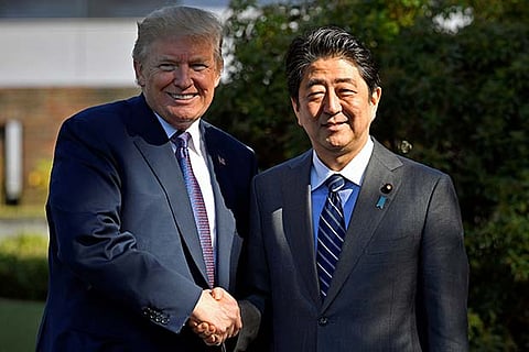 US President Donald Trump (L) shakes hands with Japanese Prime Minister Shinzo Abe upon his arrival