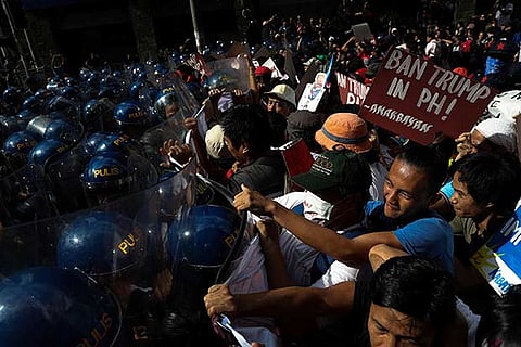 Protesters clash with anti-riot police officers as they try to march towards the US embassy, Manila
