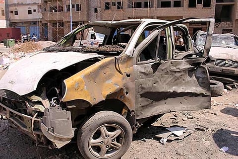 Damaged cars seen near the site of a suicide car bomb attack in Aden, Yemen