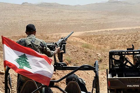 Lebanese Army soldiers ride on their military vehicles
