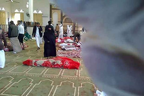 Egyptians gather around bodies following a gun and bombing attack at the Rawda mosque