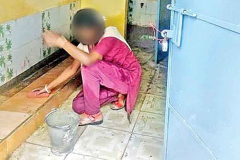 A girl student cleaning the toilet at RM Jain Government School