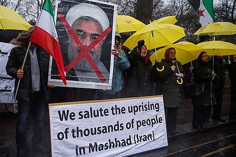 Opponents of Iranian President Hassan Rouhani hold a protest