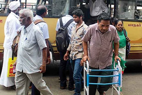 A commuter, who needs a walking aid, seen struggling to get off a bus