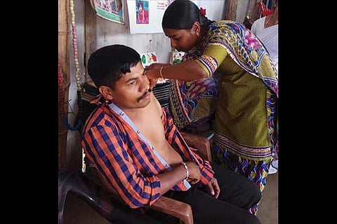 A health official administers vaccine  to a resident of a village near Mudumalai