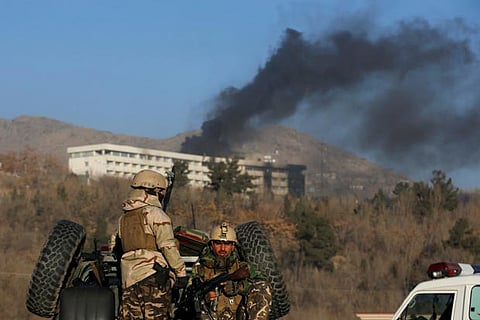 Afghan security forces keep watch as smoke rises from the Intercontinental Hotel in Kabul