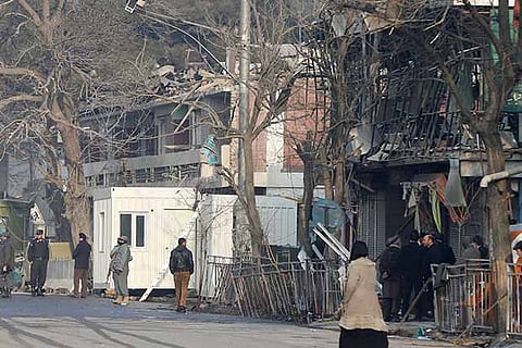 Afghan policemen inspect the site of a bomb attack in Kabul, Afghanistan