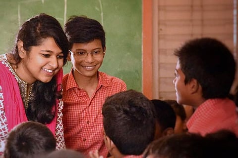A college student interacting with school kids at a campaign of the You and Us, an NGO