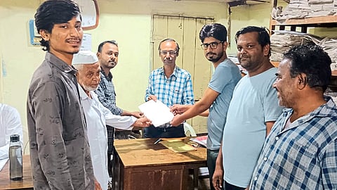 Traders and residents giving a statement to Clerk Deshpande at Mahadistribution office.