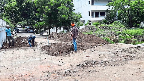 Workers filling a ditch beside a drain in Jayanagar.