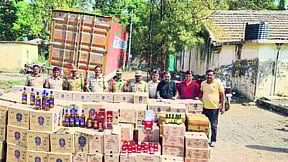 Police officers and personnel along with the stock of foreign liquor seized in the police operation.