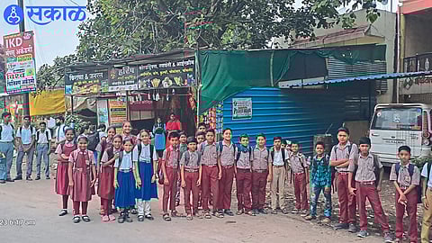 Students waiting for the bus at the bus stop.

