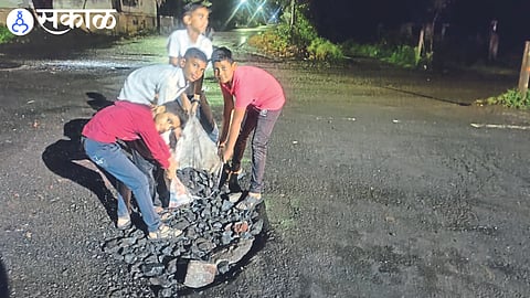 Students plugging the pothole that caused the accident on Friday night.