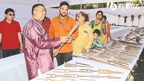 Nashikkar seeing the Shivkaline weapon presented at the Mahasanskriti Mahotsav.