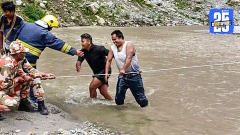 Flood-hit village in Assam submerged after torrential rain; locals wade through waist-deep water as homes collapse and landslides block roads