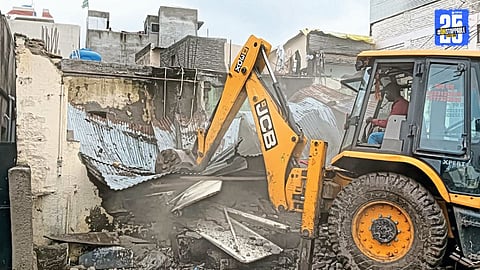 JCB deployed by Ahilyanagar Municipal Corporation to demolish illegal slaughterhouses following local protests.