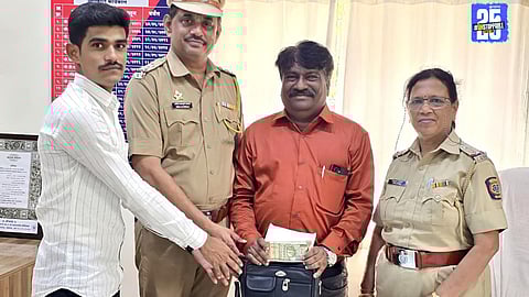 Pali Police officers handing over the recovered bag with cheques worth ₹4 lakh to its rightful owner.