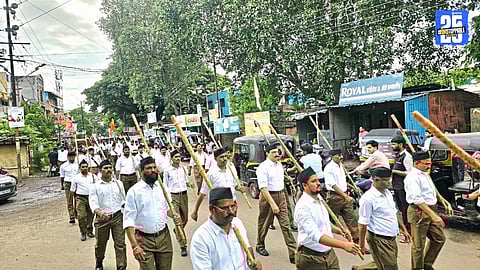 Thousands of RSS swayamsevaks participating in the centenary year procession with disciplined formations and echoing slogans.