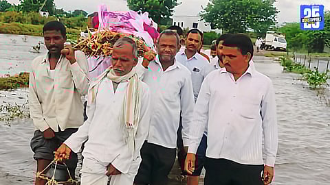 Funeral procession wading through knee-deep water in flood-hit Chopdi and Nazare villages, Solapur.