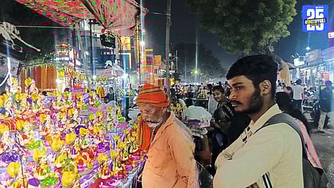 Citizens shopping for books during Diwali festivities as the city shines with diyas; police manage security to control crowd.