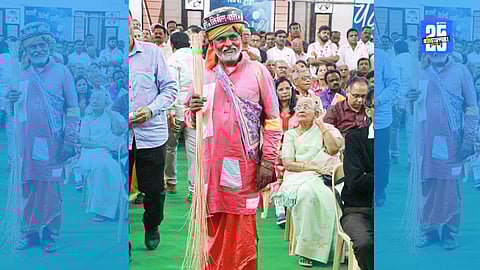 Actor portraying modern Gadgebaba with broom and earthen pot during Sahitya Sammelan performance.