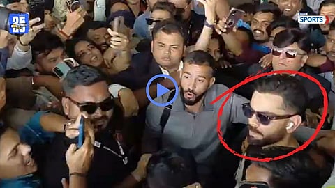 Virat Kohli being escorted by security after fans surrounded him at Vadodara Airport