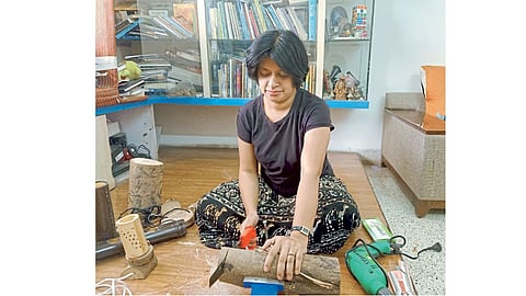 लाकडी कलाकृती बनविताना आदिती देवधर.