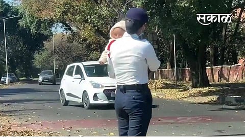 woman constable traffic carrying her baby