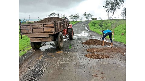 आंबळे - निगडे-आंबळे रस्त्यावरील खड्डे बुजविताना तरुण.