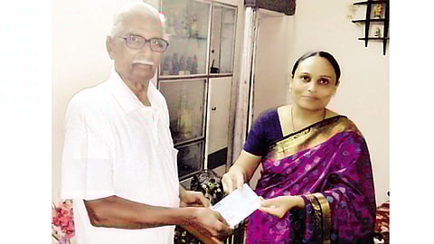घोगली शाळेच्या शिक्षिका पाैर्णिमा पडधान यांना मदतीचा धनादेश देताना शंकरराव जाधव.