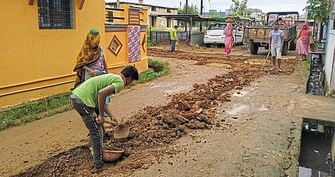 गडचिरोली : मलनिःसारणाचा पाइप टाकल्यावर रस्ता बुजवताना मजूर.