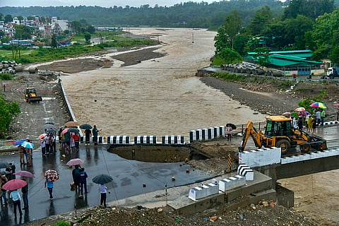 People gather after a section of a bridge caves in following heavy rainfall, in Dehradun, on July 28 | File image/PTI