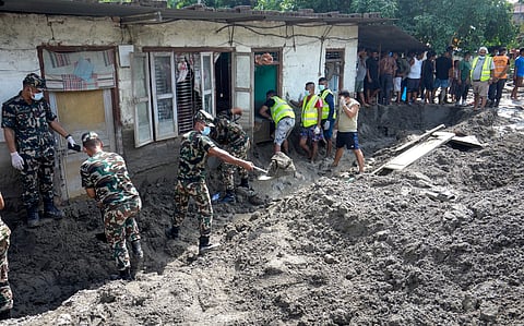 Army personnel shovel thick mud and debris to clear houses inundated by severe flash floods, in Dhading district, Nepal, on Saturday | PTI