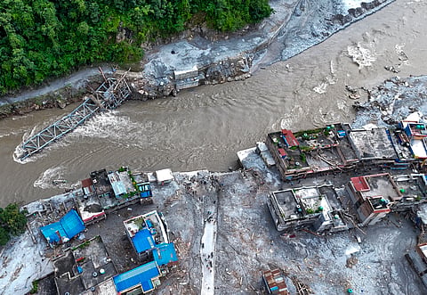 An aerial view shows damaged structures covered in thick mud and debris along side a swollen river following the devastating flash floods at Devighat village, in Nuwakot district, Nepal | PTI