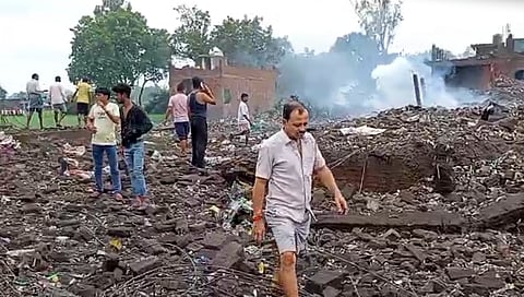 People gather after an explosion in a firecracker factory, in Pipri area, Kaushambi, on Monday | PTI
