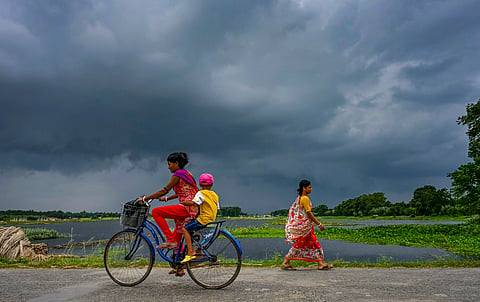 Children sit together on a bicycle under an overcast monsoon sky, in Nadia district, West Bengal, on Monday | File image/PTI