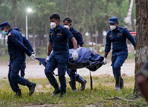 Nepal Police personnel carry the body of a victim at a military base, in Nuwakot district, Nepal, on Monday | PTI